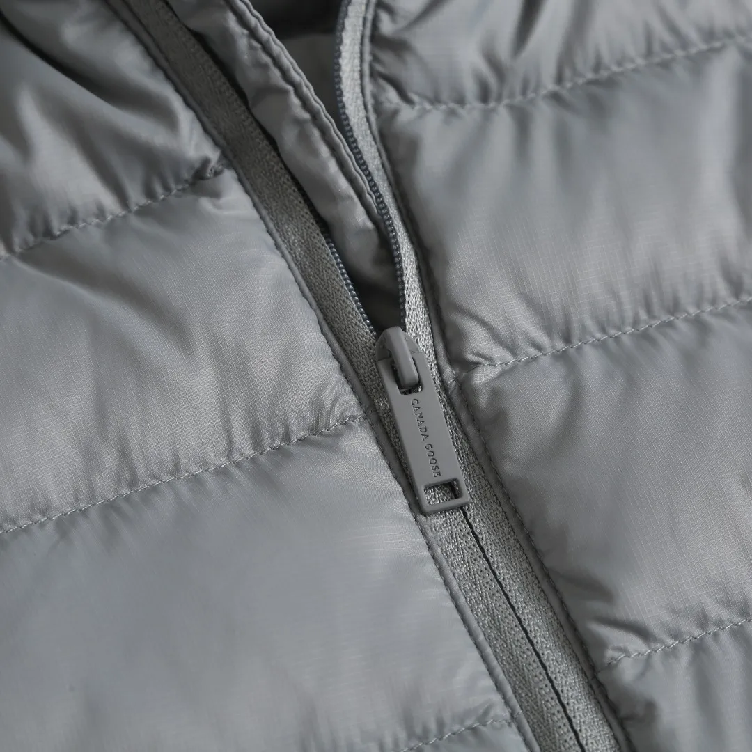 BP Can Goos Quilted Badge Down Jacket Fabric Selection: Made of nylon fiber through high-density lattice tear-proof weaving process, the surface forms a fine checkered texture, and the warp and weft yarns are interlaced to strengthen the structural toughness of the fabric, effectively blocking external pull, and making it less prone to snagging, tearing and damage. After dense post-finishing treatment, the fabric surface is light and compact, with a soft matte texture. It also has windproof properties and can block the penetration of cold wind. The texture of the fabric is light and soft, without any heavy or stiff feeling, and the upper body does not feel weighed down. It also has good anti-wrinkle properties. It is not easy to produce stubborn wrinkles after rubbing, and it is not easy to leave dead wrinkles after daily storage and folding. It is easy to care for, taking into account both lightness and durability. Quilting technology: Using horizontal segmented lock velvet quilting technology, the stitching is straight and regular, and the stitch spacing is even and fine. Divide the garment body into regular horizontal down filling compartments to effectively fix the down inside, prevent the down from clumping and shifting after wearing and washing, and allow the down to be evenly distributed in each cavity. The seams are made with tight workmanship, the pinholes are small, and the high-density fabrics greatly reduce the risk of velvet getting out. The overall quilting lines are simple and neat, creating a simple and smooth body shape, without being bloated and bloated, and the upper body is flat and straight. The sleeves and body are individually quilted, giving both freedom of movement and velvet locking capabilities. High-quality filling: 90% white duck down is selected as the filling material for the inner lining. It has a high velvet content, full and fluffy velvet, few impurities, and excellent temperature-locking and warmth-preserving properties. The whole piece is filled with about 170g of down. The amount of down is sufficient and the filling is full and even. It can lock the air to form a thermal insulation layer and effectively block the intrusion of cold air from the outside. Details: The inner cuffs are equipped with elastic bands to naturally form a micro-cinch effect. The cuffs are smooth and dense, the stitching at the fabric splicing is even, and the workmanship is meticulous. The elastic structure can fit the wrist tightly, effectively prevent cold wind from entering through the cuffs, and lock in the warmth inside. It has moderate stretch and elasticity, so it doesn't strangle your wrists when worn, and your arms can be raised and raised without being restricted. At the same time, it can prevent the cuffs from moving up during wearing, making it easy to put on and take off. The placket adopts hemming technology, and the hemming strip completely covers the raw edge of the placket piece, storing all the trimmed edges to prevent the edge yarn from being exposed. The width of the hemming is uniform, the wiring is consistent and smooth, and the corners are clean and neat, without wrinkles or bulging. Accessories: One-to-one customized embroidery stamp, One-to-one customized zipper puller, One-to-one customized three-label Size: S M L XL Style number: D